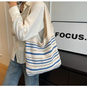 Vista detallada del bolso de hombro tejido a ganchillo con rayas beige y azul, estilo casual.