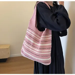 Escena detallada de un bolso de hombro de punto a rayas rosas y blancas elegante y casual.