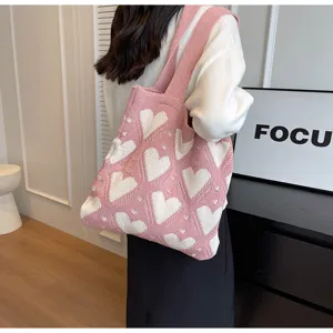 Detailed view of women pink knit tote bag with white hearts, cute casual shoulder bag for daily.