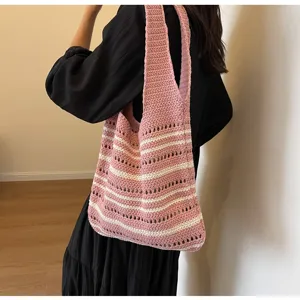 Detalle del bolso de hombro tejido con un hermoso diseño de rayas rosas y blancas.