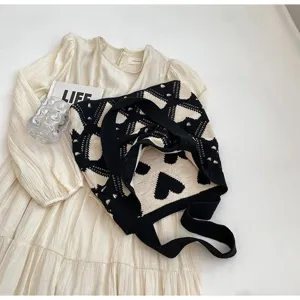 Detailed view of the stylish knitted tote bag, featuring a classic black and white heart pattern.
