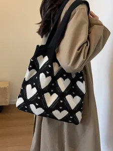 Chic black knit shoulder bag featuring white heart patterns and spacious design for daily commute.
