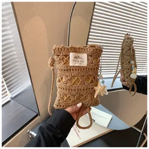 Vue détaillée d'un sac bandoulière de téléphone en crochet avec pendentif étoile et étiquette.