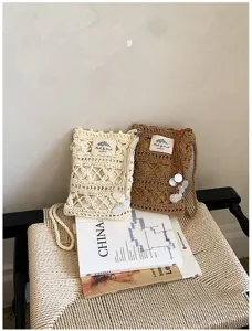 Sac tissé ajouré de style artistique avec franges ethniques et décor de coquillages de plage.