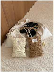Gros plan du mini sac bandoulière au crochet fait main, pochette téléphone plage.