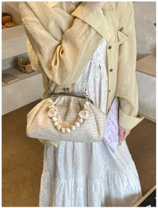 Sac en paille coquillage tissé avec détail de poignée perlée élégant pour la plage et vacances.