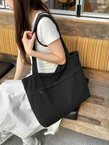 Dettaglio borsa shopper in tela nera, borsa a tracolla casual per uso quotidiano.