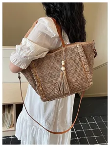 Stylish vacation straw woven crossbody bag with tassel and beads, perfect for summer beach travel.