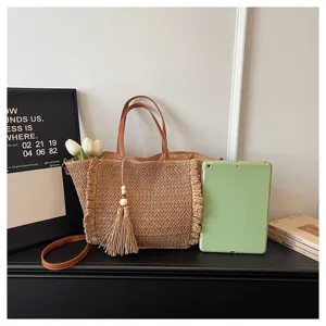 Straw woven shoulder bag detail view, featuring large capacity and elegant tassel pendant.