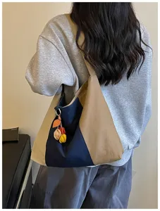 Gedetailleerd overzicht van vintage kleurenblok canvas tote tas met leuke hanger.