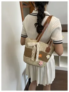 Sac à main en paille tissée avec fleurs et nœud, parfait pour les vacances à la plage.