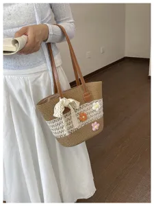 Détail en gros plan du sac de plage tressé avec nœud en dentelle et jolies fleurs au crochet.