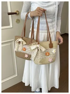 Vue détaillée du sac cabas de plage en paille avec fleurs au crochet et ruban de dentelle.