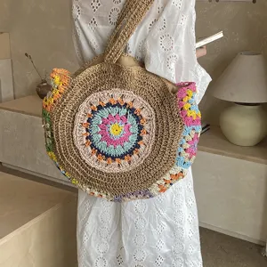 Λεπτομέρεια τσάντας ώμου από ψάθα boho, πολύχρωμο λουλουδάτο σχέδιο, καλοκαιρινή παραλία.