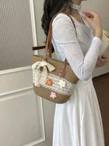 Sac à bandoulière en paille chic pour femme avec décor floral, idéal pour les vacances d'été.