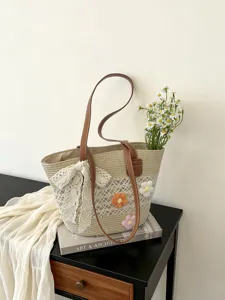 Sac de plage tissé en paille pour femme avec fleurs, sac d'épaule décontracté et chic.