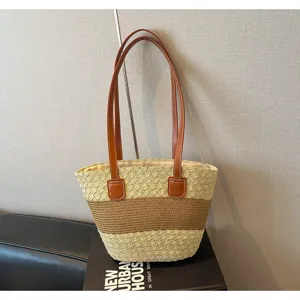 Vue détaillée du grand sac cabas en paille tissée avec poignées et bandes contrastées.