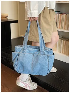 Κοντινή λήψη της casual τσάντας tote από τζιν με πλαϊνές τσέπες και πρακτικό εσωτερικό χώρο.