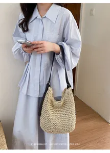 Détail d'un sac porté épaule minimaliste en paille tressée, style décontracté d'été.
