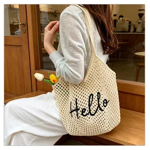 Beige Häkel Schultertasche Detail, Netz Tasche mit Hello Stickerei für Strandurlaub Sommer.