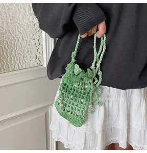 Gedetailleerd overzicht van een groen gehaakt telefoontasje met parels, perfect voor het strand.