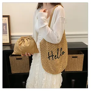 Detailaufnahme der lässigen Häkelnetz-Umhängetasche mit Hello-Stickerei und Etui.
