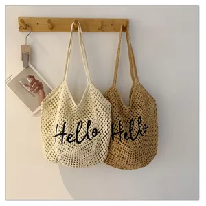 Nahaufnahme von gehäkelten Strandtaschen mit gesticktem Hello Schriftzug und Detail.