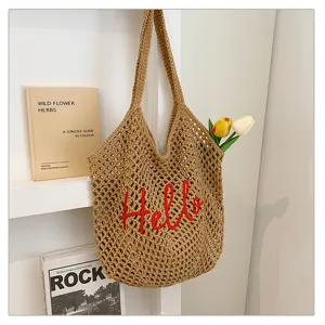 Detailansicht der gehäkelten Tasche mit roter Stickerei und sommerlichem Urlaubsdesign.