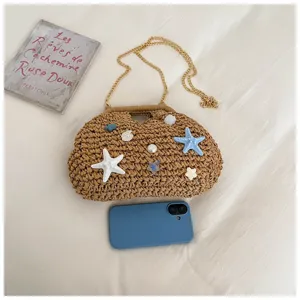 Vista dettagliata della borsa di paglia da spiaggia decorata con conchiglie e stelle marine.