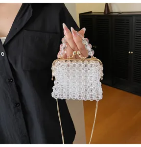 Close-up detail of clear acrylic beaded mini handbag featuring golden clasp and chain strap.