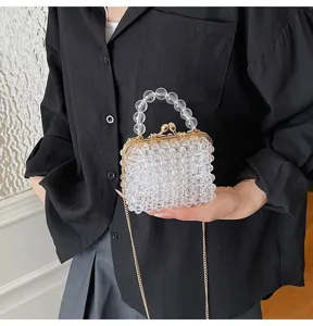 Clear detail view of the clear beaded mini handbag with gold clasp and chain strap.
