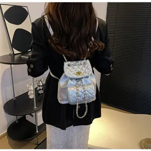 Detailansicht des silbernen gesteppten Rucksacks mit Kettengurten und schickem Design.