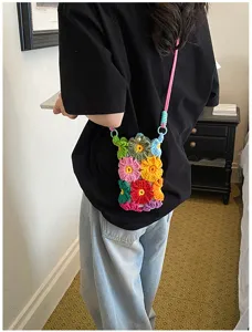 Handgemachte gehäkelte Blumen-Handytasche Detail, bunte Strick-Umhängetasche mit Tragegurt.