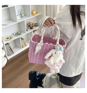 Detailed view of the pink woven handbag with cute plush rabbit pendant and stylish silk scarf wrap.