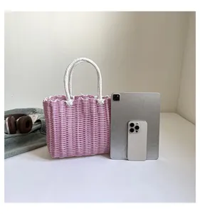 Detailed view of pink and white woven tote bag, cute summer travel beach basket for women.