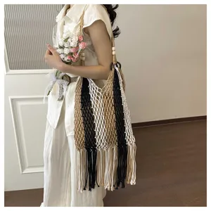 Detail shot of a bohemian handmade woven mesh shoulder bag with long fringe tassels and beads.