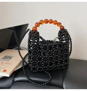 Bolso de mano negro de cuentas con asa ámbar y bandolera elegante para mujeres moda.