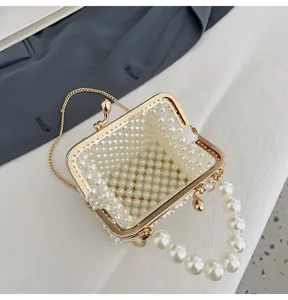 Detailed close-up top view of a cute mini pearl beaded kiss-lock handbag with gold chain.