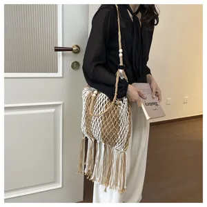 Detail view of the bohemian hollow woven shoulder bag featuring long tassels and net pattern.