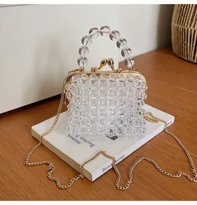 Clear beaded crossbody bag detail showing transparent crystal beads, gold kiss-lock and chain.