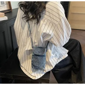 Detailed lifestyle shot of a retro denim crossbody phone bag worn on back, casual mini style.
