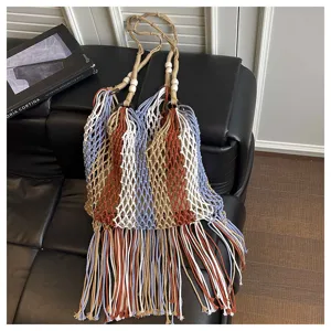 Ethnic style woven shoulder bag with long fringes, hollow beach net bag for women vacation.