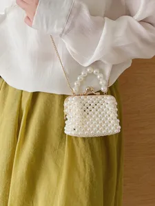 Elegant pearl beaded crossbody bag with kiss-lock clasp and stylish pearl handle accessory.