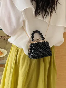 Elegant black beaded mini handbag with gold chain strap, stylish crossbody bag for women.