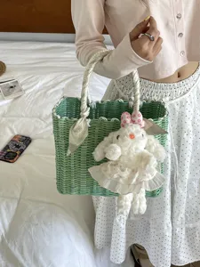 Korean style green woven handbag with scarf handle and cute plush rabbit pendant for summer travel.