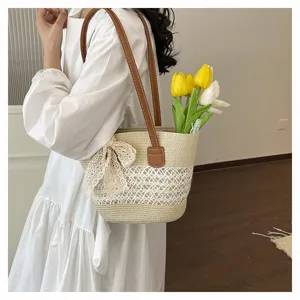 Woven straw shoulder bag detail, hollow-out design with elegant lace bow and floral decor.