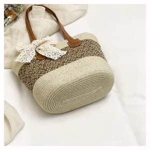 Detailed view of women straw woven handbag with brown leather handles and cute lace bow decor.