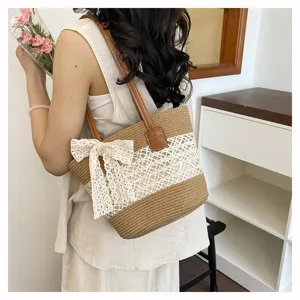 Women's straw shoulder bag with lace bow, hollow woven handbag, casual beach vacation style.