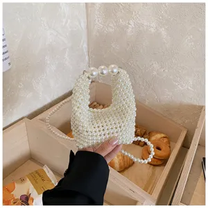 Detailed shot of a sweet style handmade pearl beaded mini handbag in a lifestyle scene display.