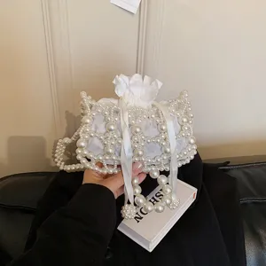 Pearl beaded mini handbag detail view, elegant white faux pearl string bag with drawstring.